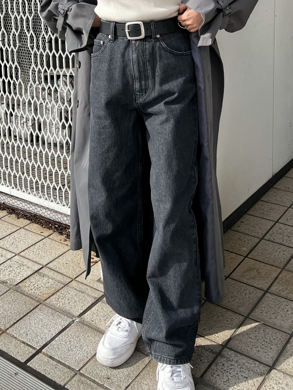 グレー系のトレンチコート、ブラック系のデニムパンツ、ブラック系のベルトを着用したレディースの冬コーディネートの8枚目の写真