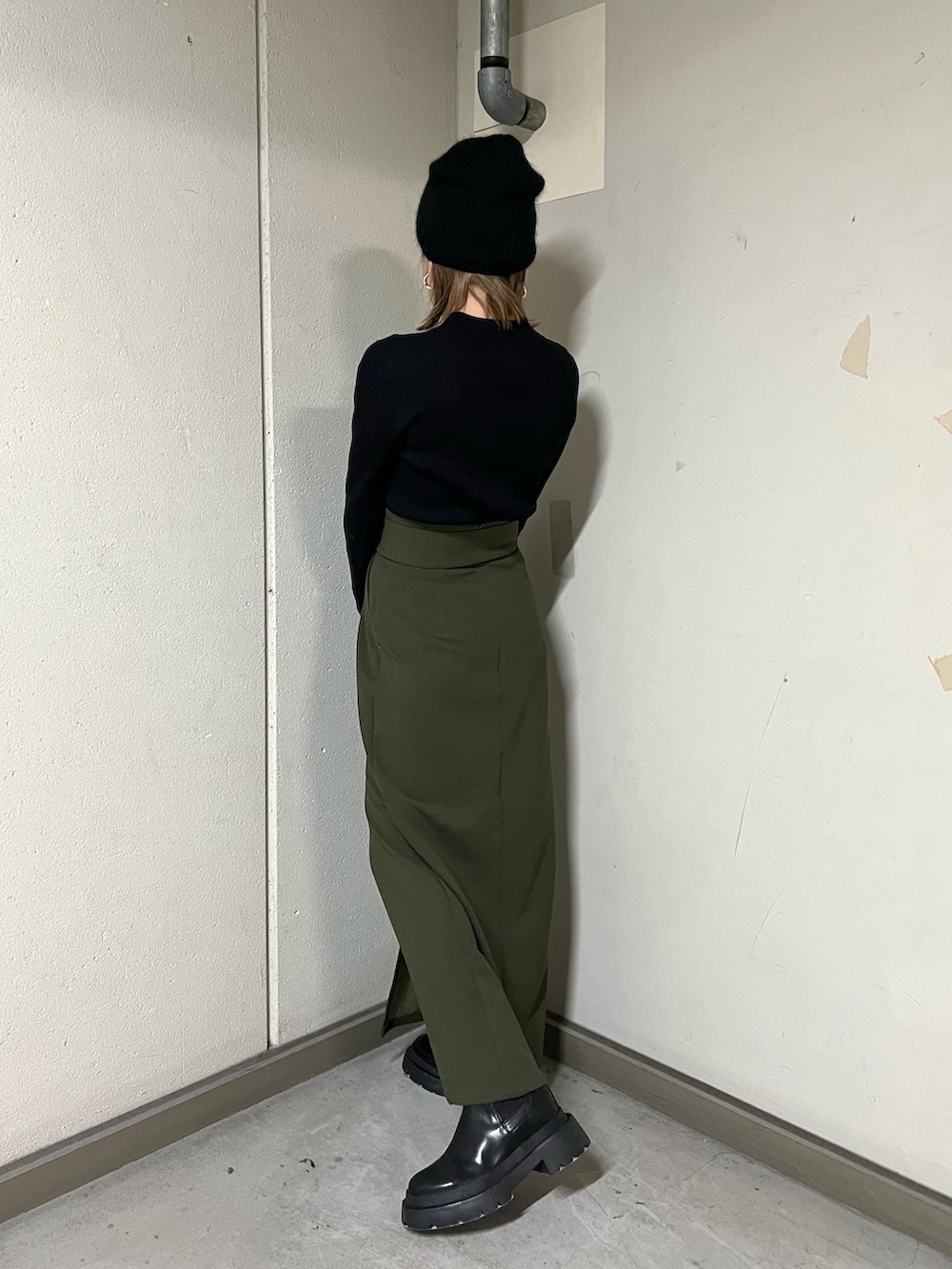 ブラック系のムートンコート、ブラック系のニット/セーター、グリーン系のスカートを着用したレディースの冬コーディネートの8枚目の写真