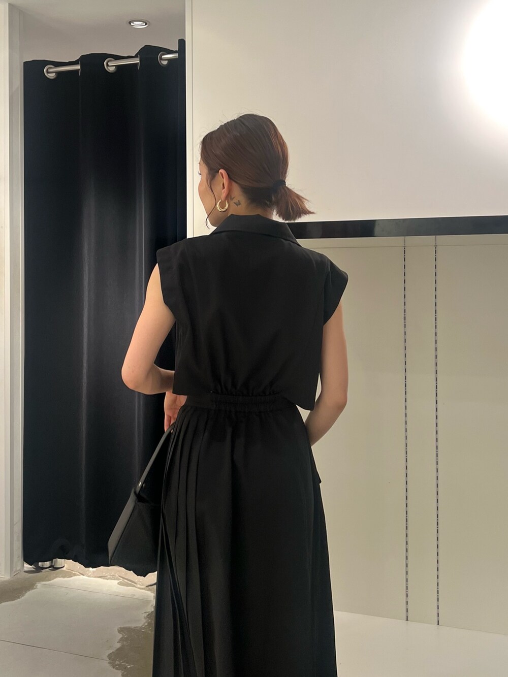 ブラック系のワンピース、ブラック系のサンダル、ブラック系のハンドバッグを着用したレディースの夏コーディネートの6枚目の写真