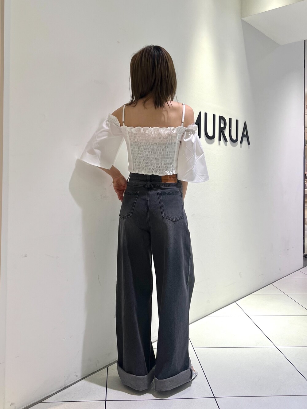 ブラック系のデニムパンツ、ホワイト系のシャツ/ブラウス、シルバー系のサンダルを着用したレディースの夏コーディネートの2枚目の写真