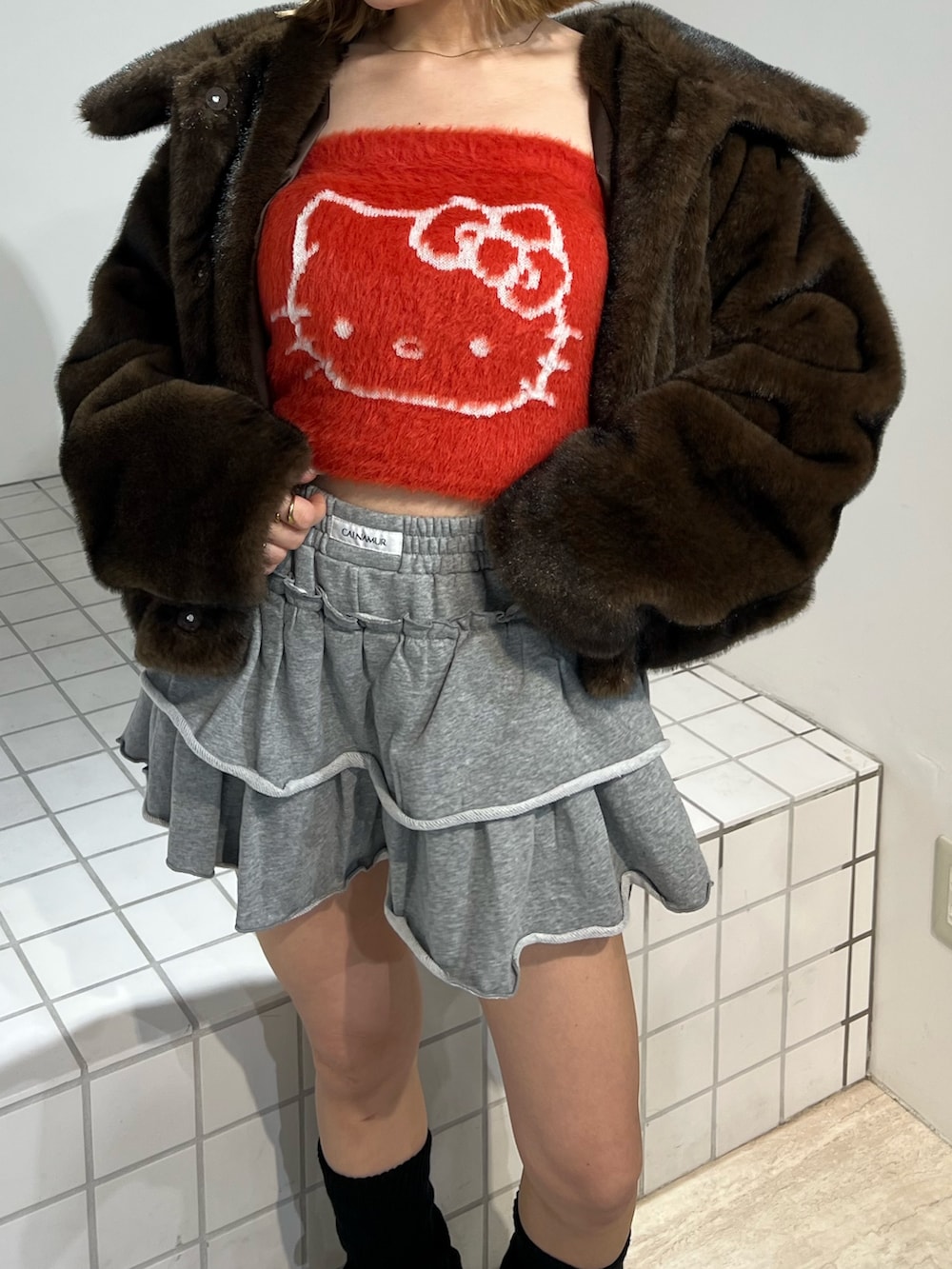 レッド系のニット/セーター、ブラウン系のブルゾン、グレー系のその他パンツを着用したレディースの冬コーディネートの5枚目の写真