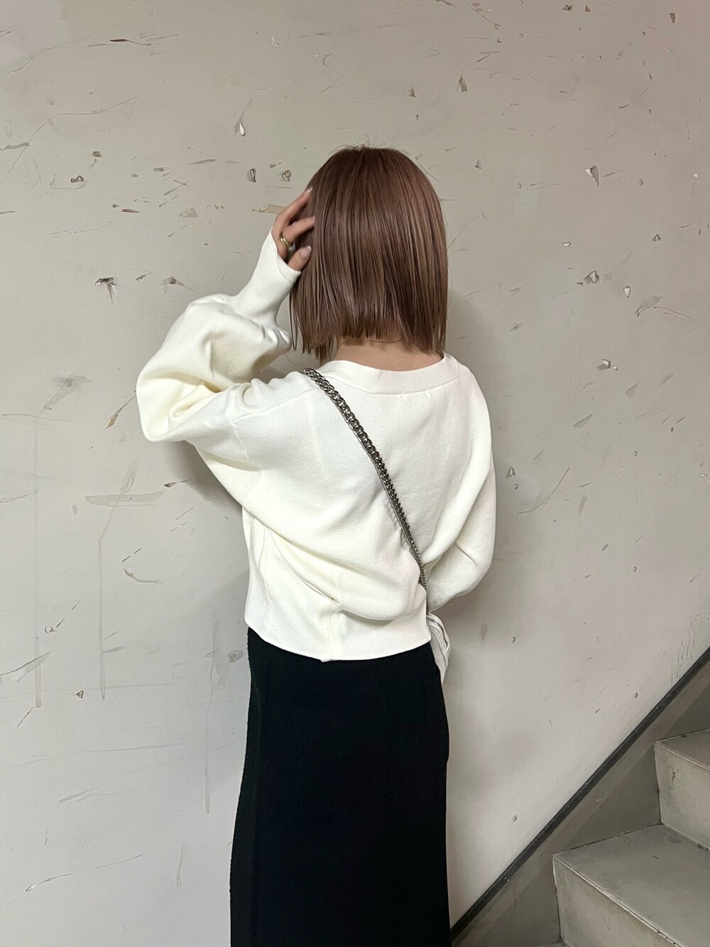 ホワイト系のブーツ、ブラック系のスカート、ホワイト系のカーディガン/ボレロを着用したレディースの冬コーディネートの5枚目の写真