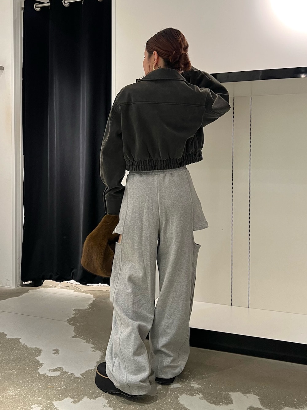 ブラック系のブルゾン、ホワイト系のTシャツ/カットソー、グレー系のスウェットパンツを着用したレディースの秋コーディネートの3枚目の写真