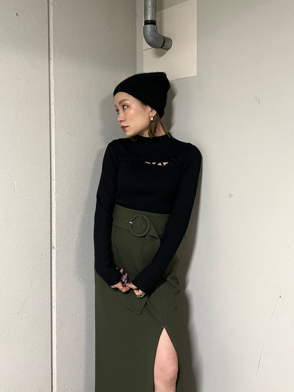 ブラック系のムートンコート、ブラック系のニット/セーター、グリーン系のスカートを着用したレディースの冬コーディネートの9枚目の写真