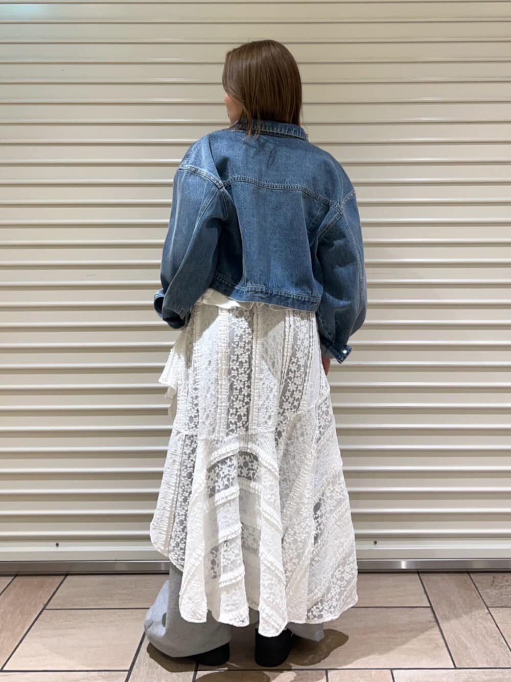 ブルー系のデニムジャケット、ホワイト系のワンピース、グレー系のその他パンツを着用したレディースの春コーディネートの3枚目の写真