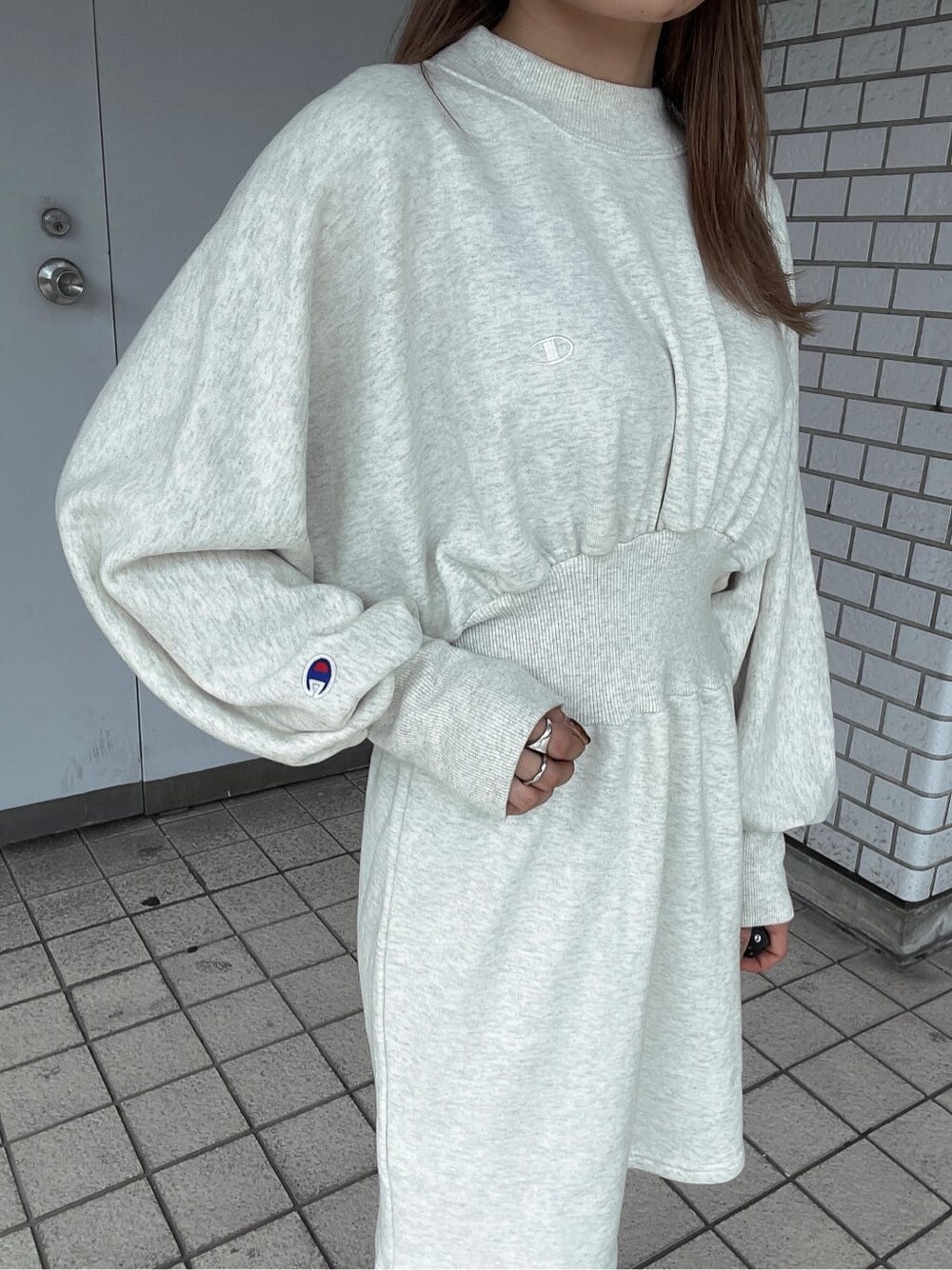 ホワイト系のワンピース、ブラック系のブーツ、ブラック系のブルゾンを着用したレディースの秋コーディネートの9枚目の写真