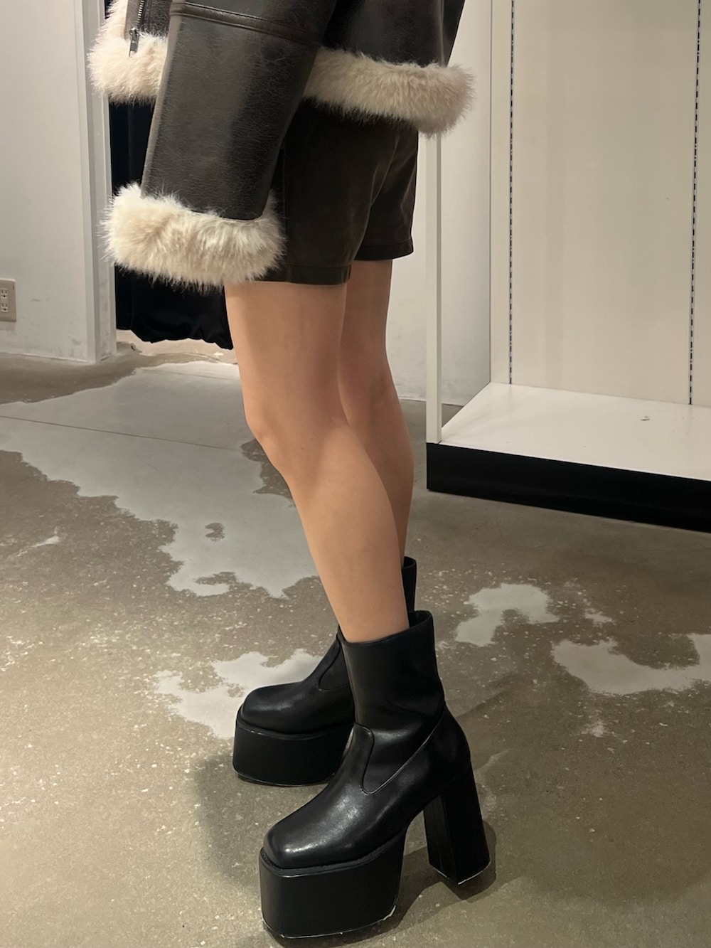 ブラウン系のムートンコート、ホワイト系のニット/セーター、ブラウン系のその他パンツを着用したレディースの秋コーディネートの7枚目の写真