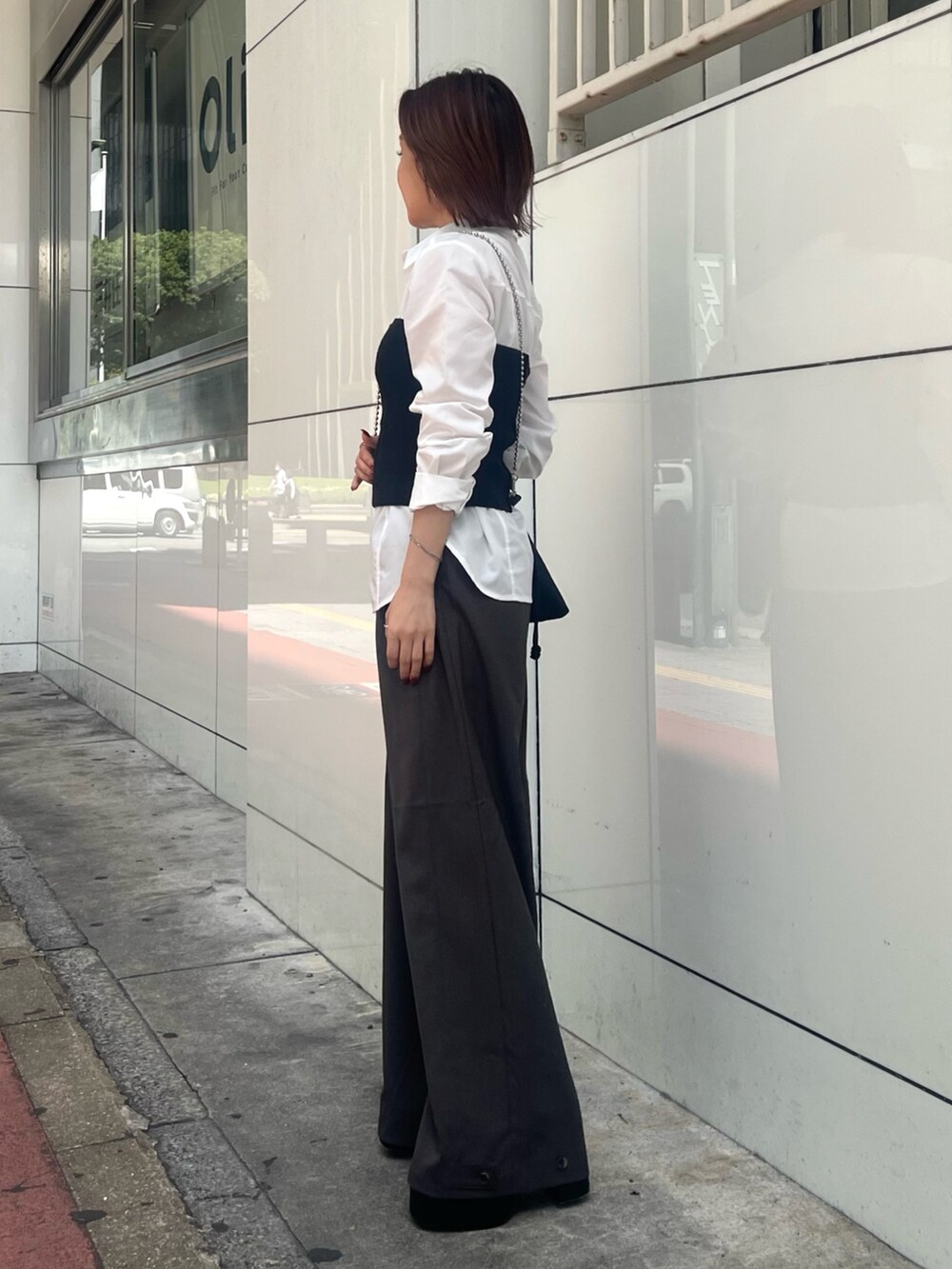 ブラック系のブーツ、ホワイト系のシャツ/ブラウス、ブラック系のニット/セーターを着用したレディースの秋コーディネートの3枚目の写真