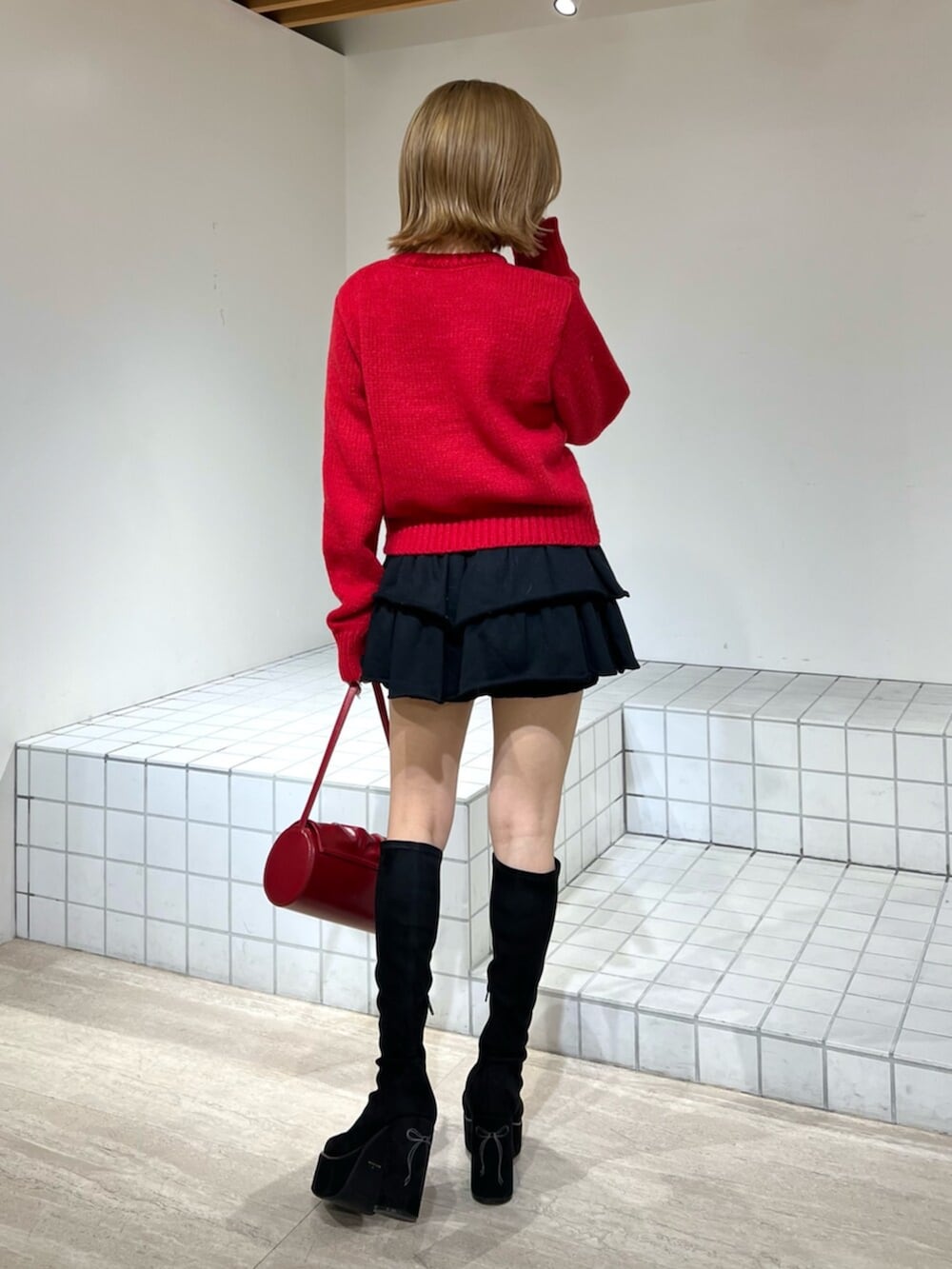 ブラック系のその他パンツ、ブラック系のブーツ、レッド系のハンドバッグを着用したレディースの冬コーディネートの2枚目の写真