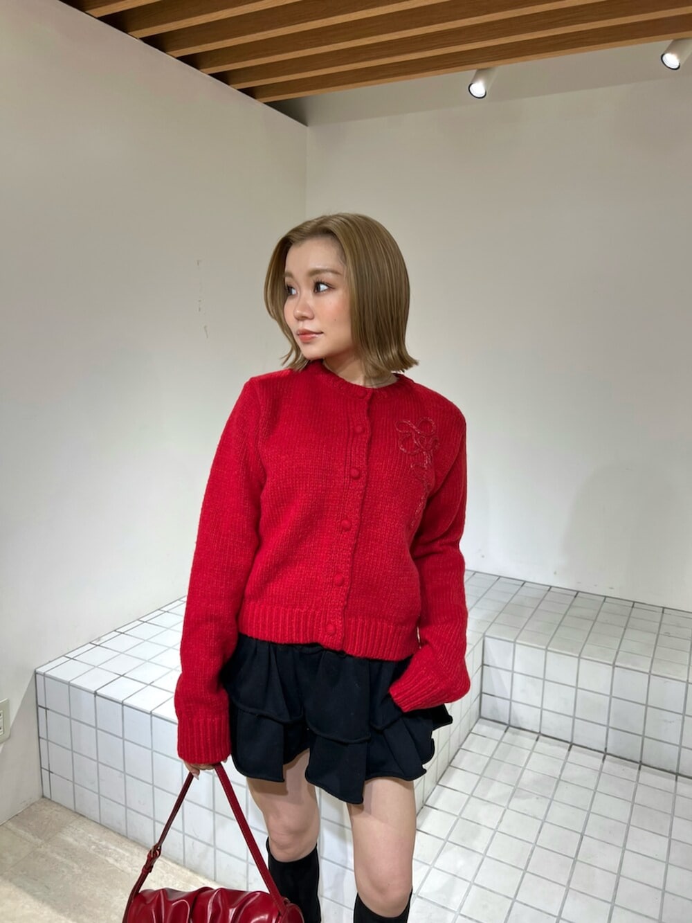 ブラック系のその他パンツ、ブラック系のブーツ、レッド系のハンドバッグを着用したレディースの冬コーディネートの4枚目の写真