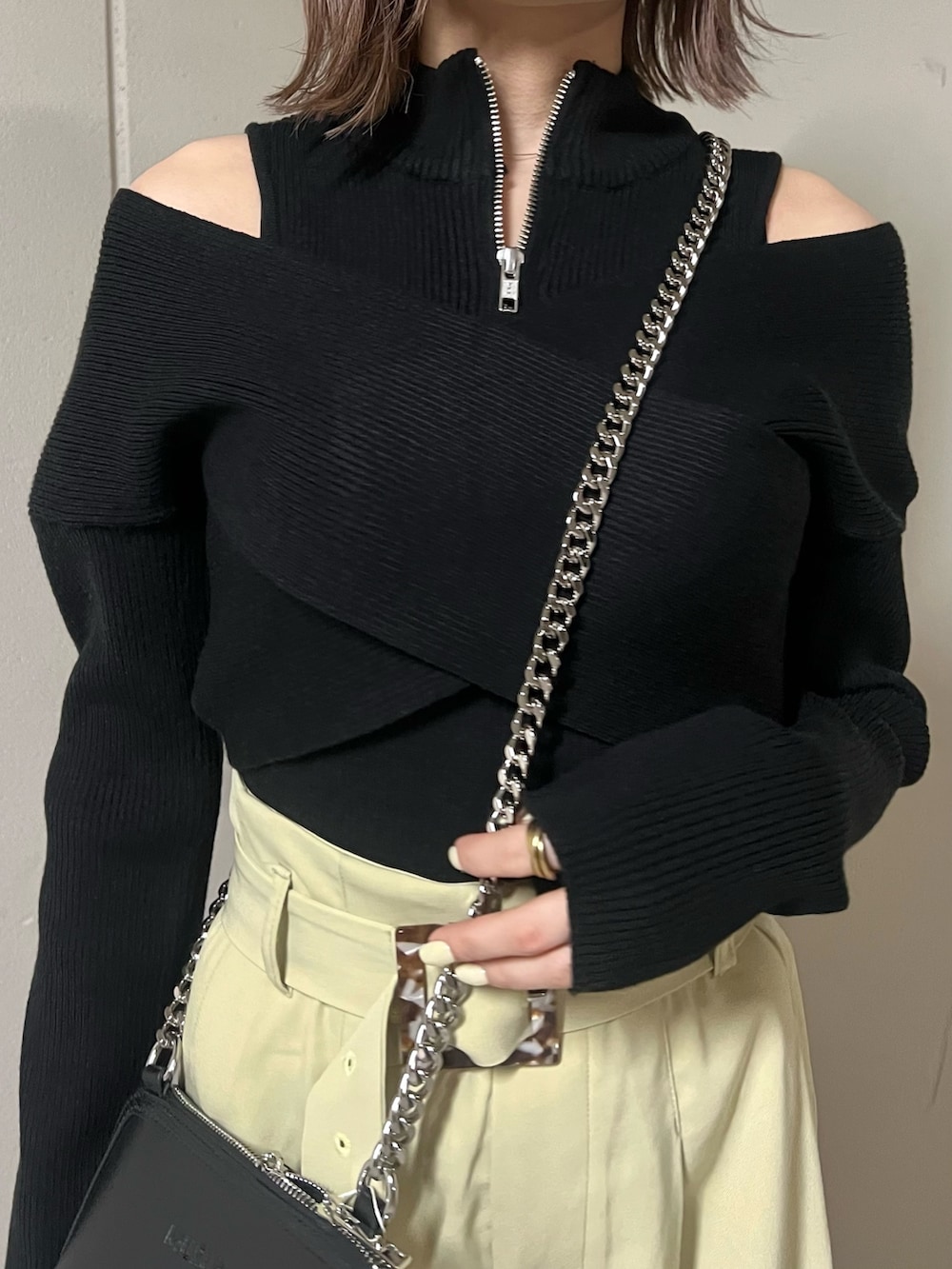 ブラック系のニット/セーター、ブラック系のハンドバッグ、ブラック系のブーツを着用したレディースの冬コーディネートの7枚目の写真