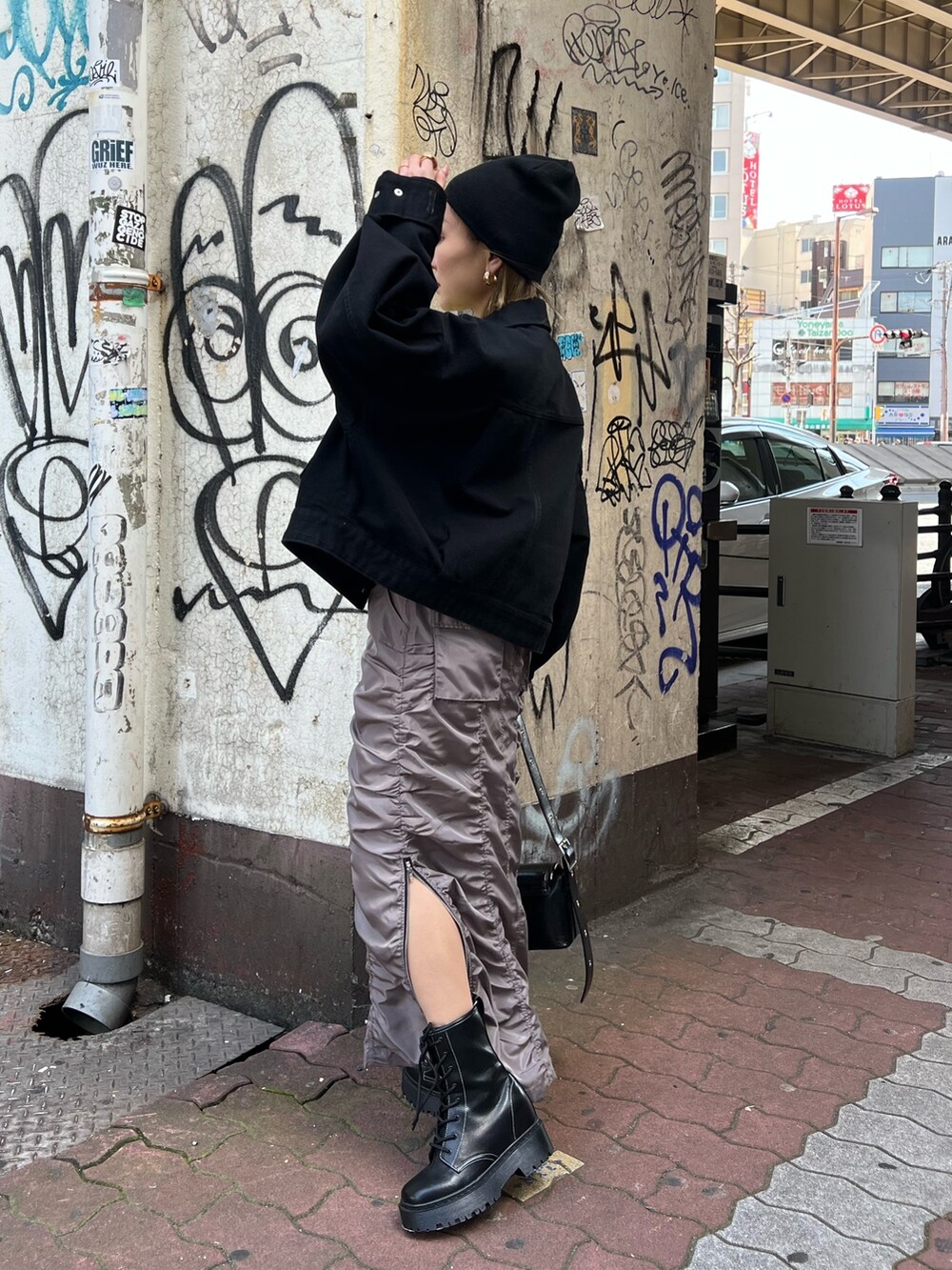 イエロー系のTシャツ/カットソー、ブラック系のデニムジャケット、グレー系のスカートを着用したレディースの春コーディネートの4枚目の写真