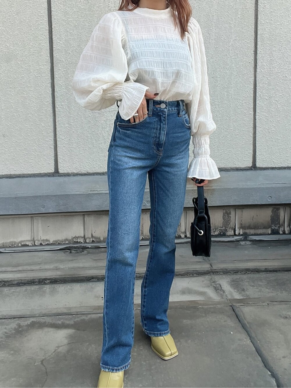 ブルー系のデニムパンツ、ホワイト系のシャツ/ブラウス、ブラック系のハンドバッグを着用したレディースの夏コーディネートの7枚目の写真