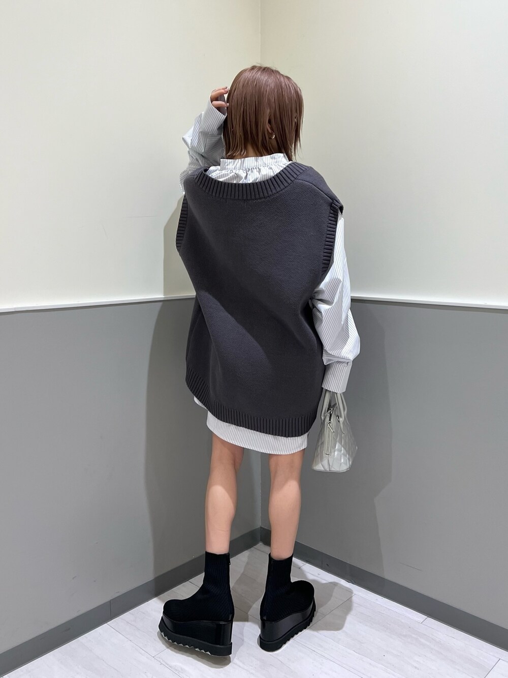 グレー系のベスト、シルバー系のハンドバッグ、その他のシャツ/ブラウスを着用したレディースの冬コーディネートの4枚目の写真