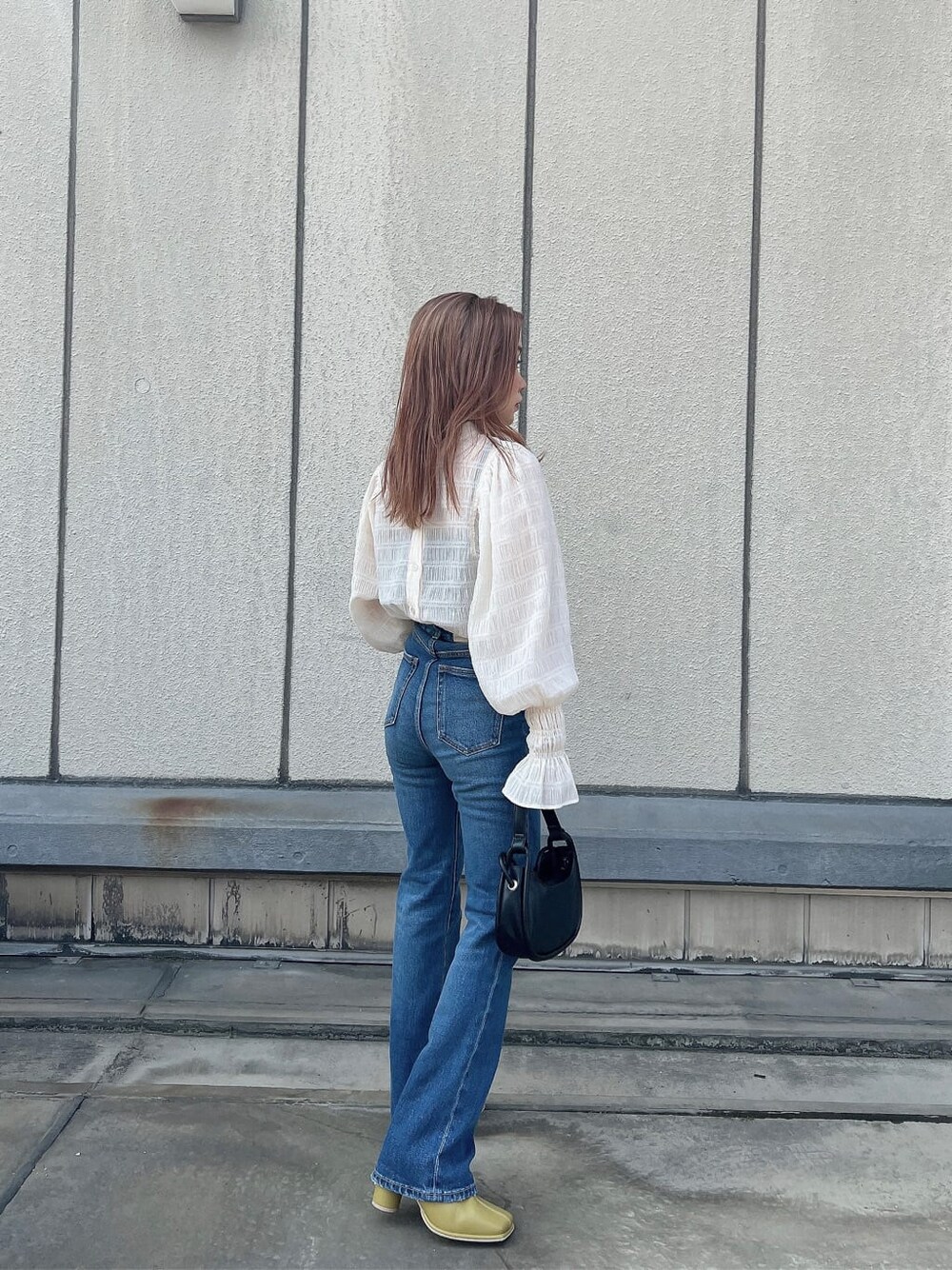 ブルー系のデニムパンツ、ホワイト系のシャツ/ブラウス、ブラック系のハンドバッグを着用したレディースの夏コーディネートの4枚目の写真