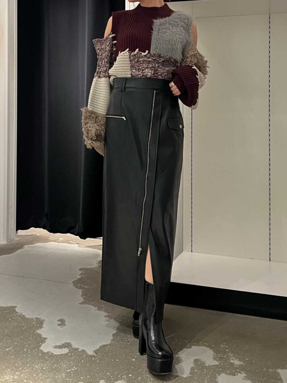 ブラック系のブーツ、レッド系のニット/セーター、ブラック系のスカートを着用したレディースの秋コーディネートの4枚目の写真