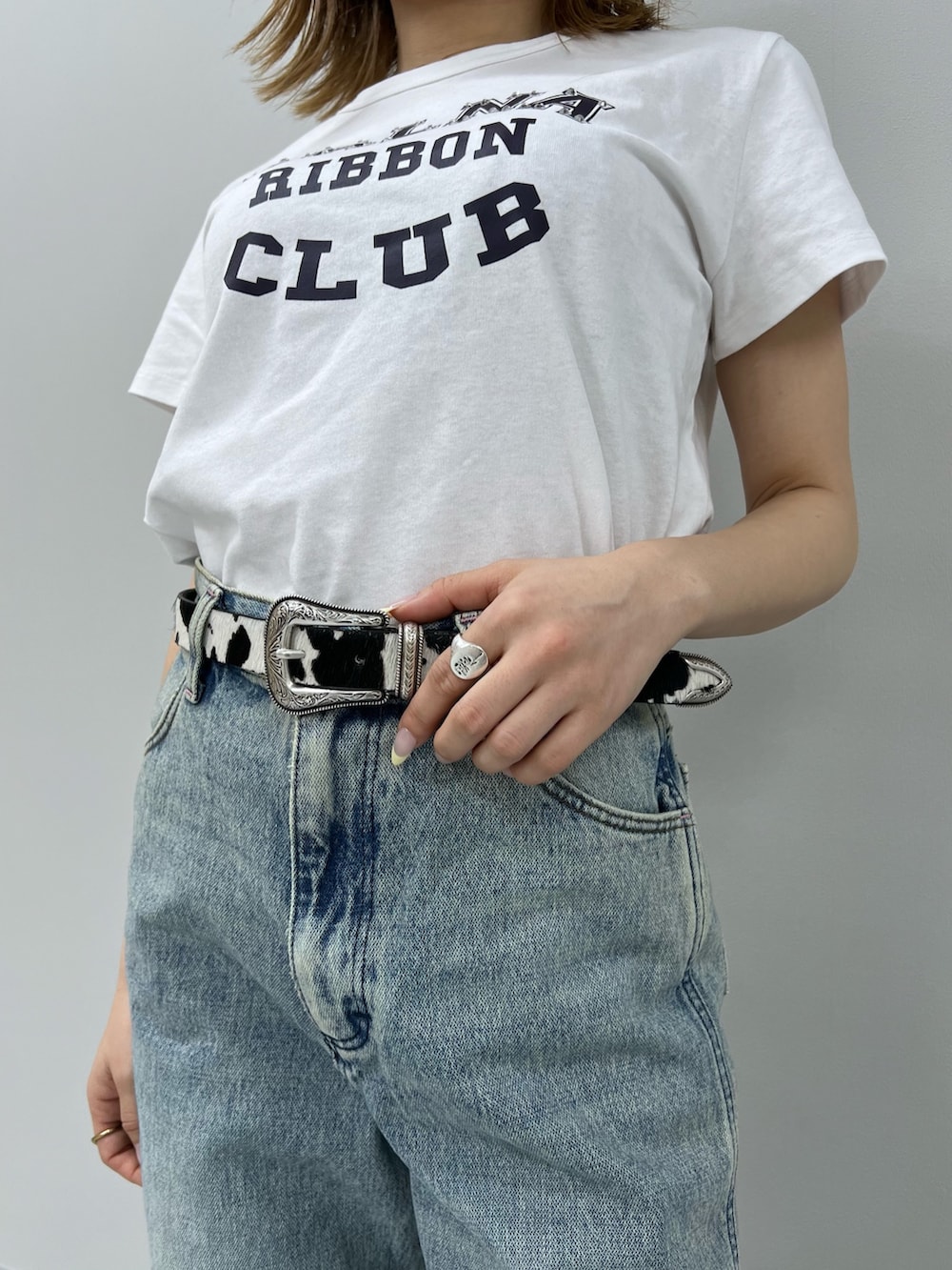 ブルー系のデニムパンツ、ホワイト系のTシャツ/カットソー、ブラウン系のブーツを着用したレディースの春コーディネートの6枚目の写真