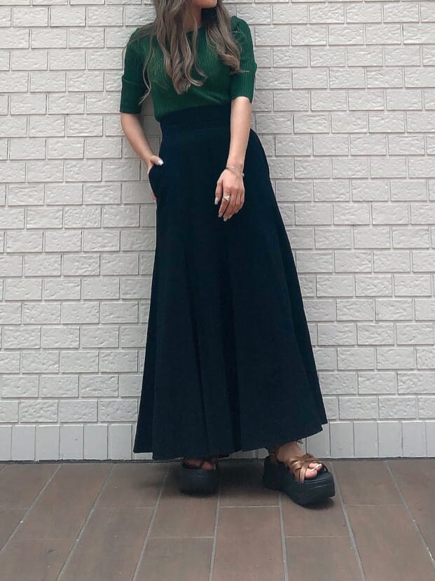 ブラック系のスカート、グリーン系のニット/セーター、ブラック系のハットを着用したレディースの夏コーディネートの5枚目の写真