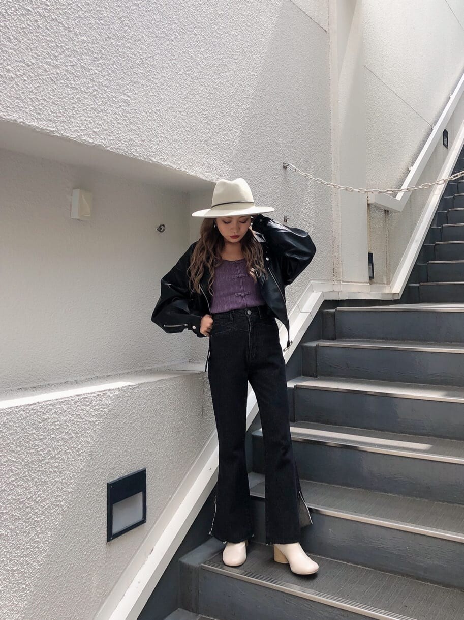 ホワイト系のブーツ、パープル系のニット/セーター、ブラック系のデニムパンツを着用したレディースの秋コーディネートの2枚目の写真