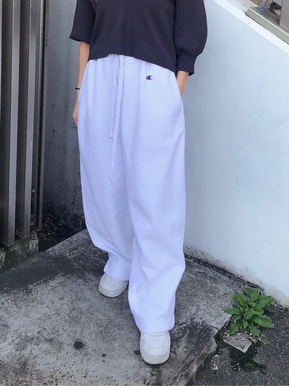 ホワイト系のスウェットパンツ、グレー系のニット/セーター、ブラック系のハットを着用したレディースの春コーディネートの6枚目の写真