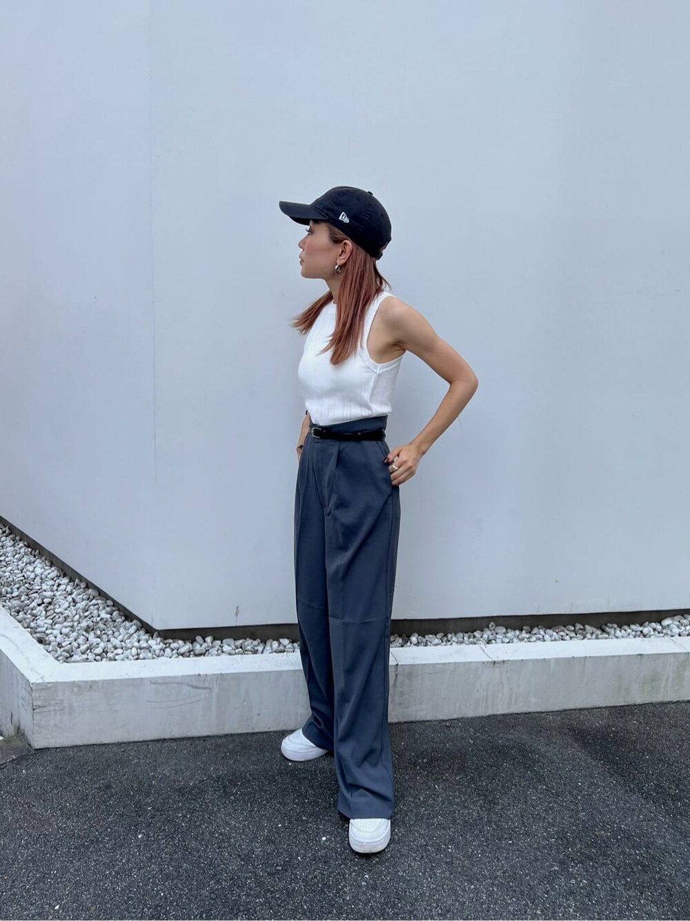 ホワイト系のタンクトップ、グレー系のスラックス、ブラック系のベルトを着用したレディースの夏コーディネートの2枚目の写真