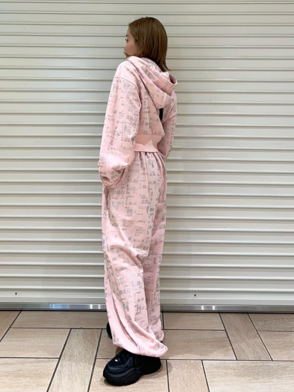 ピンク系のセットアップ、ブラック系のショルダーバッグを着用したレディースの春コーディネートの2枚目の写真