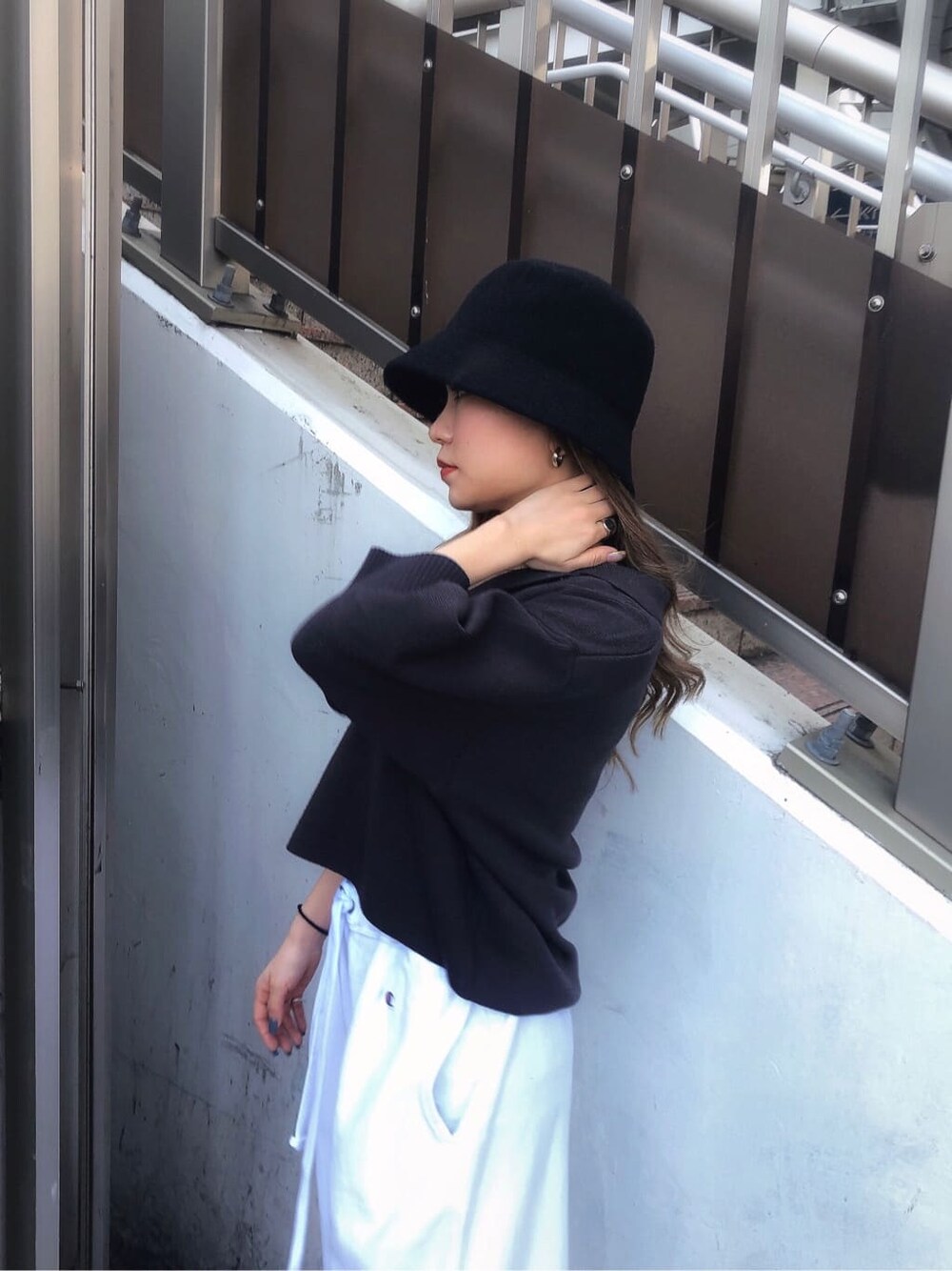 ホワイト系のスウェットパンツ、グレー系のニット/セーター、ブラック系のハットを着用したレディースの春コーディネートの7枚目の写真