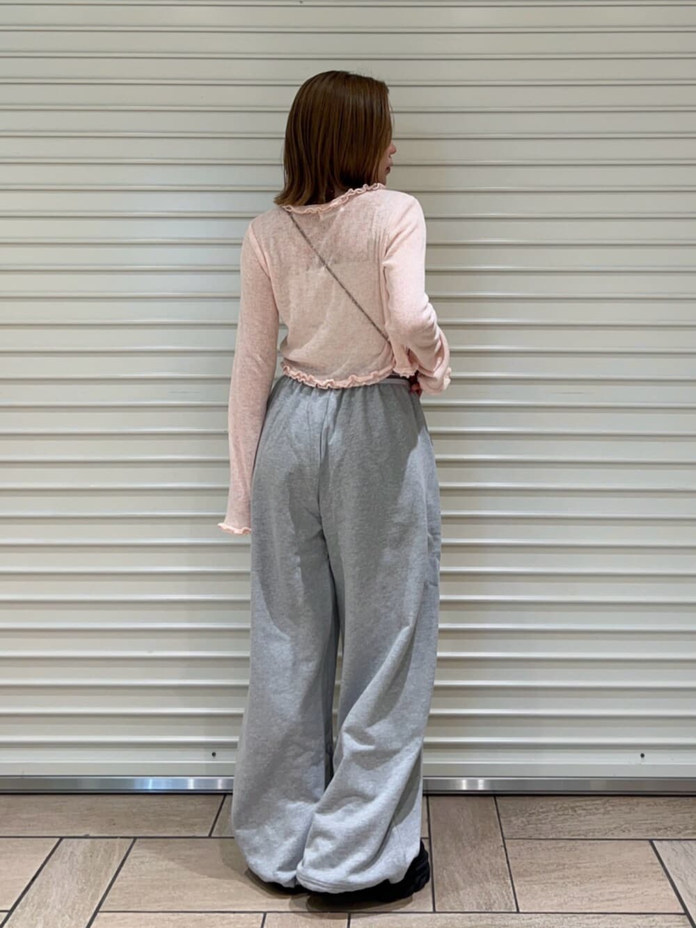 グレー系のその他パンツ、ピンク系のニット/セーターを着用したレディースの春コーディネートの3枚目の写真