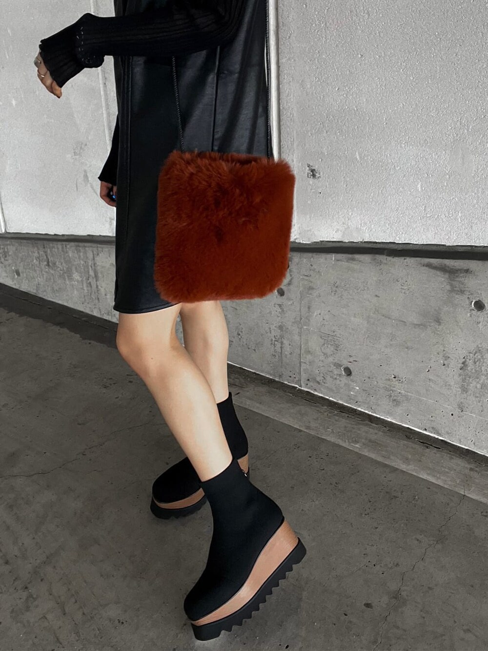 ブラック系のニット/セーター、ブラウン系のショルダーバッグ、ブラック系のワンピースを着用したレディースの秋コーディネートの8枚目の写真