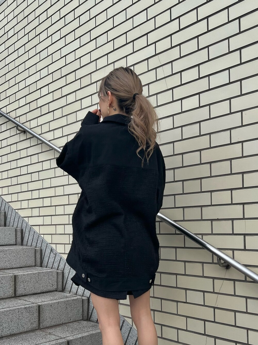 ブラック系のブルゾン、ブラック系のカーゴパンツ、ブラック系のローファーを着用したレディースの冬コーディネートの5枚目の写真