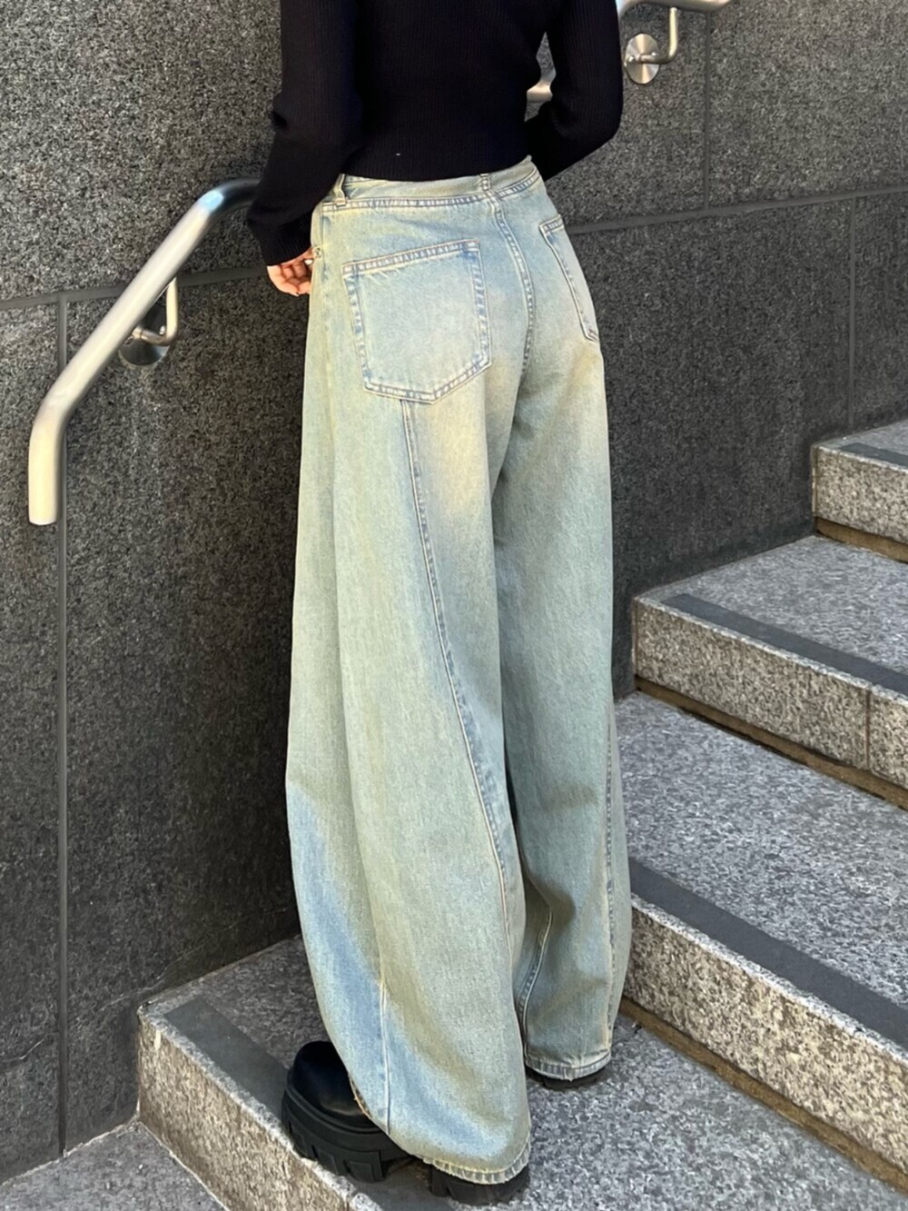 ブルー系のデニムパンツ、ブラック系のニット/セーターを着用したレディースの冬コーディネートの7枚目の写真