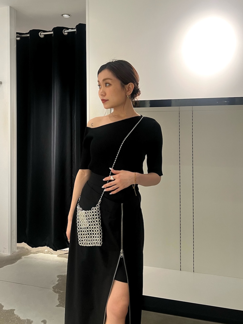 ブラック系のスカート、ブラック系のサンダル、シルバー系のショルダーバッグを着用したレディースの春コーディネートの4枚目の写真