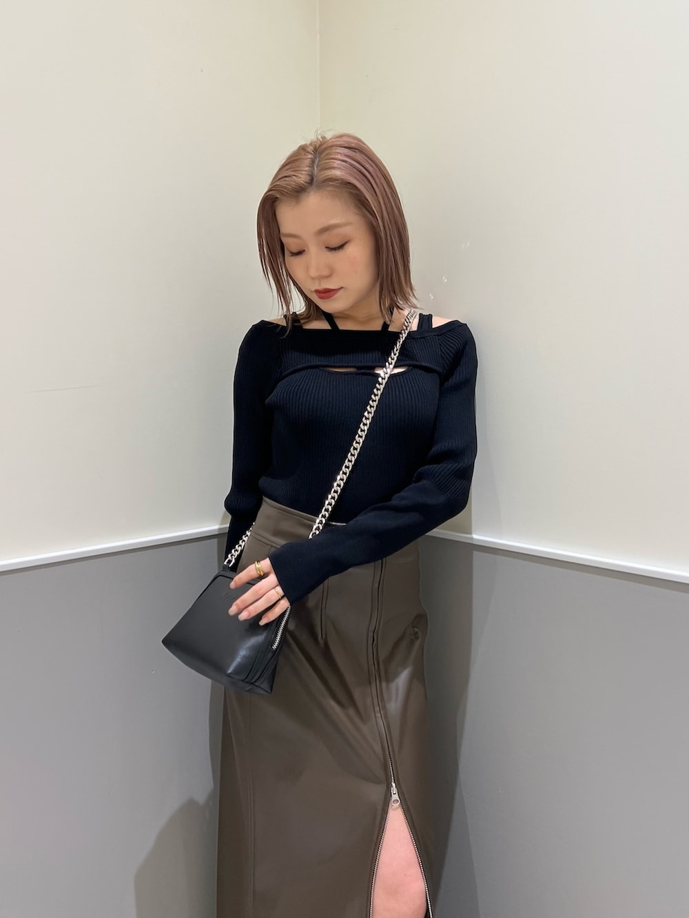 ブラック系のニット/セーター、ブラック系のブーツ、ブラウン系のスカートを着用したレディースの冬コーディネートの5枚目の写真