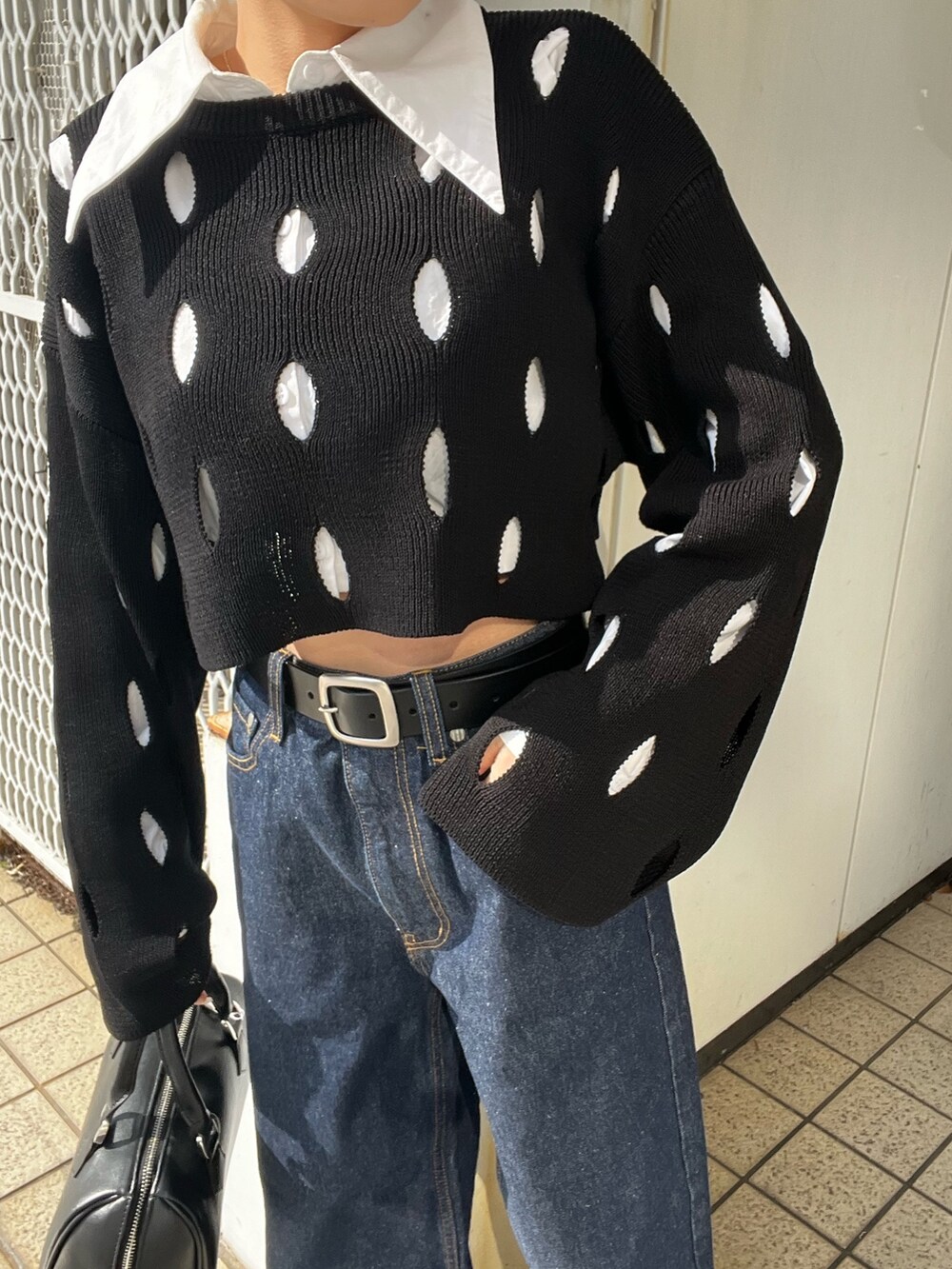 ブルー系のデニムパンツ、ホワイト系のローファー、ブラック系のニット/セーターを着用したレディースの冬コーディネートの7枚目の写真