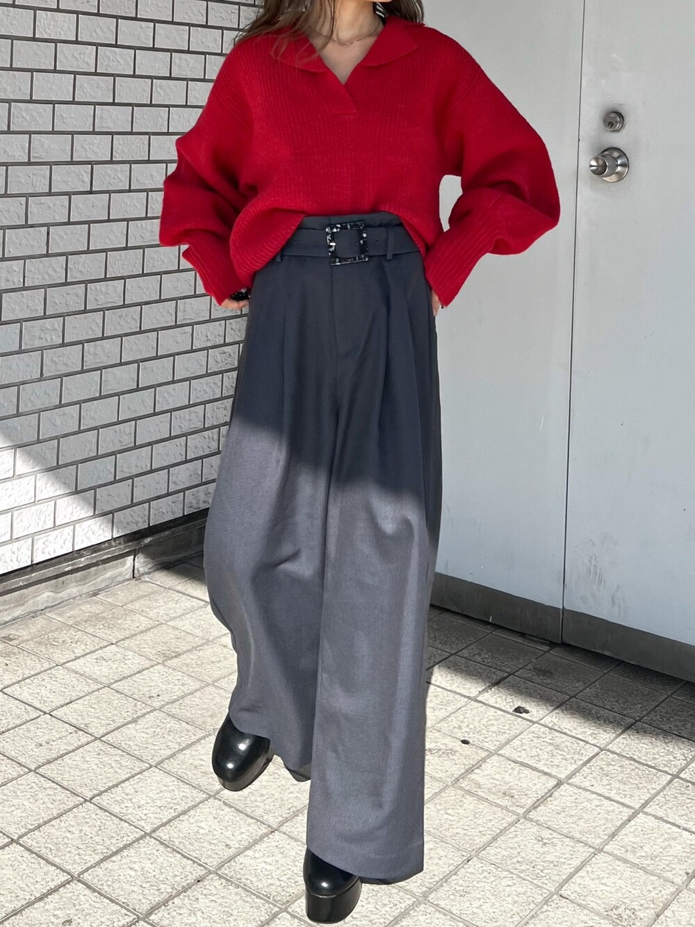 レッド系のニット/セーター、ブラック系のダウンジャケット/コート、ブラック系のブーツを着用したレディースの秋コーディネートの8枚目の写真