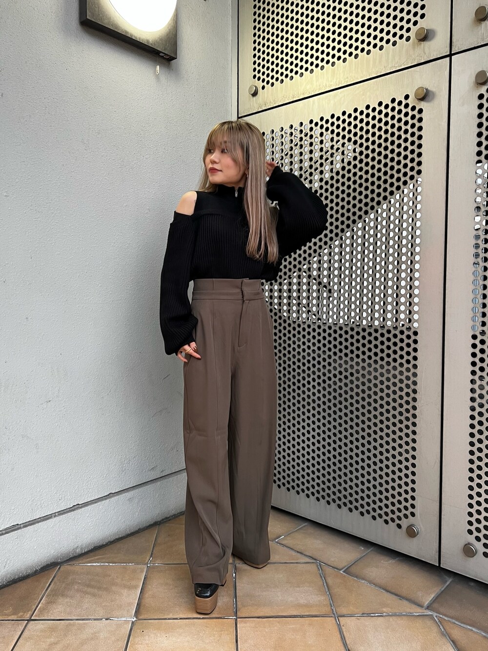 ブラック系のニット/セーター、ブラウン系のスラックス、ブラック系のローファーを着用したレディースの冬コーディネートの4枚目の写真