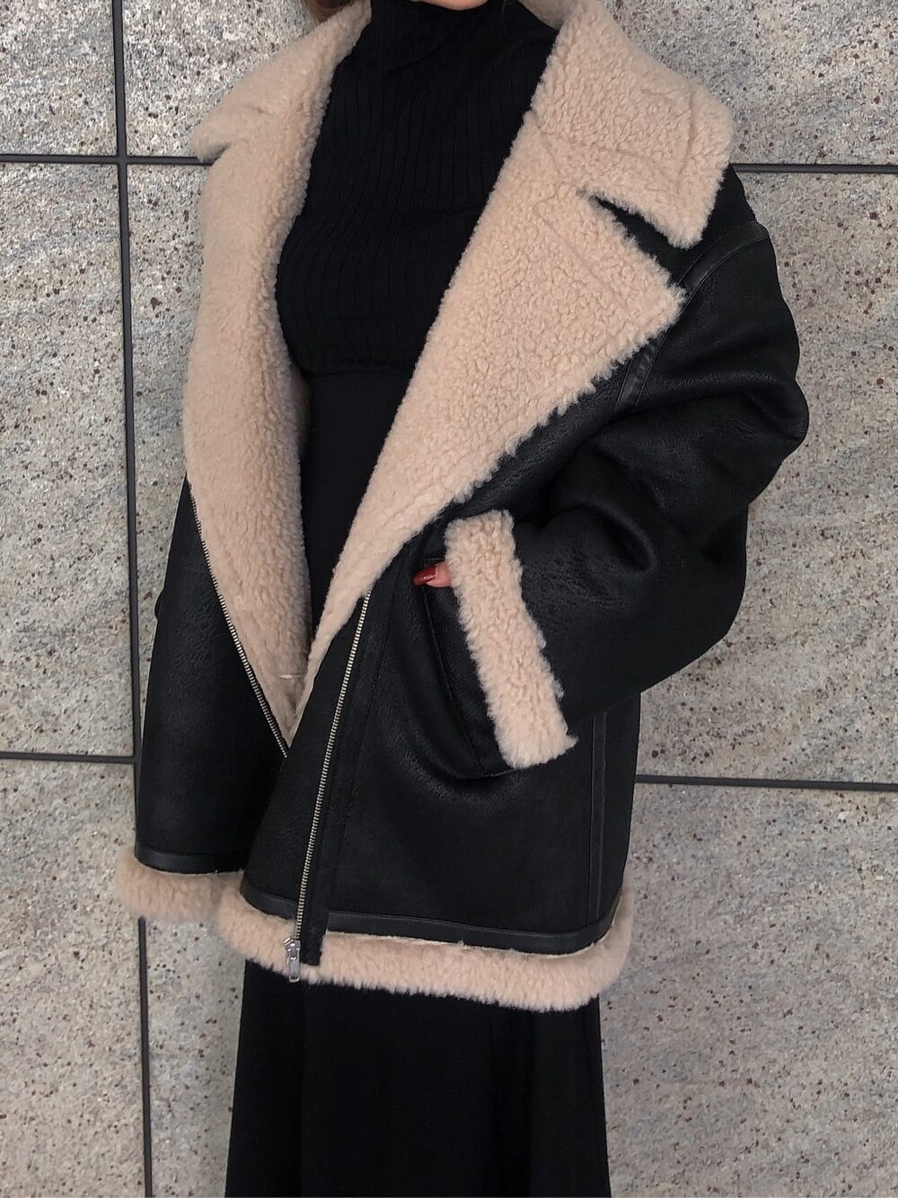 ブラック系のスカート、ブラック系のブルゾン、ブラック系のブーツを着用したレディースの秋コーディネートの6枚目の写真