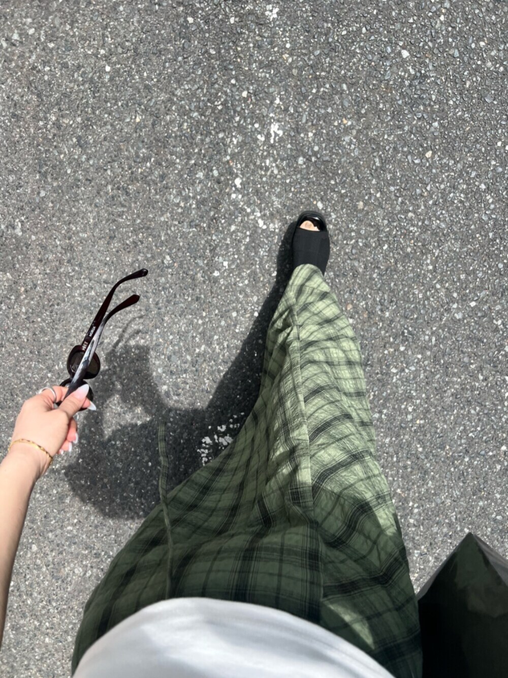 ブラック系のサンダル、ホワイト系のTシャツ/カットソー、グリーン系のスカートを着用したレディースの春コーディネートの8枚目の写真