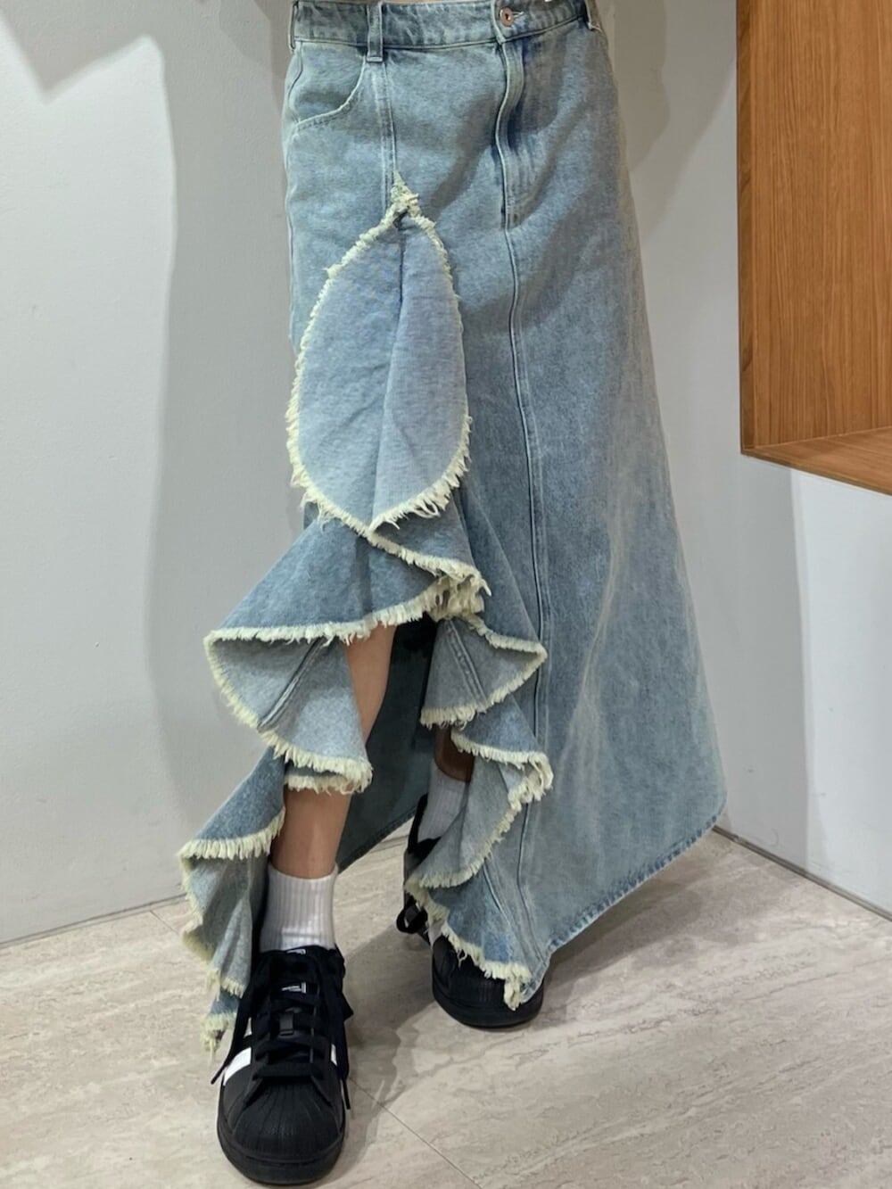 ブルー系のスカート、ブルー系のニット/セーター、ブラウン系のブルゾンを着用したレディースの冬コーディネートの5枚目の写真