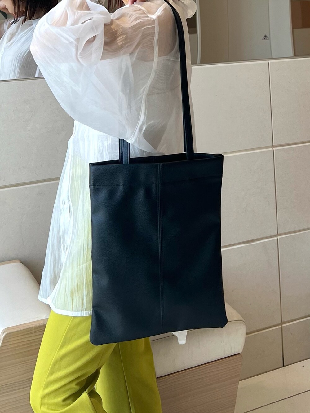 ホワイト系のシャツ/ブラウス、ホワイト系のタンクトップ、ブラック系のトートバッグを着用したレディースの春コーディネートの7枚目の写真