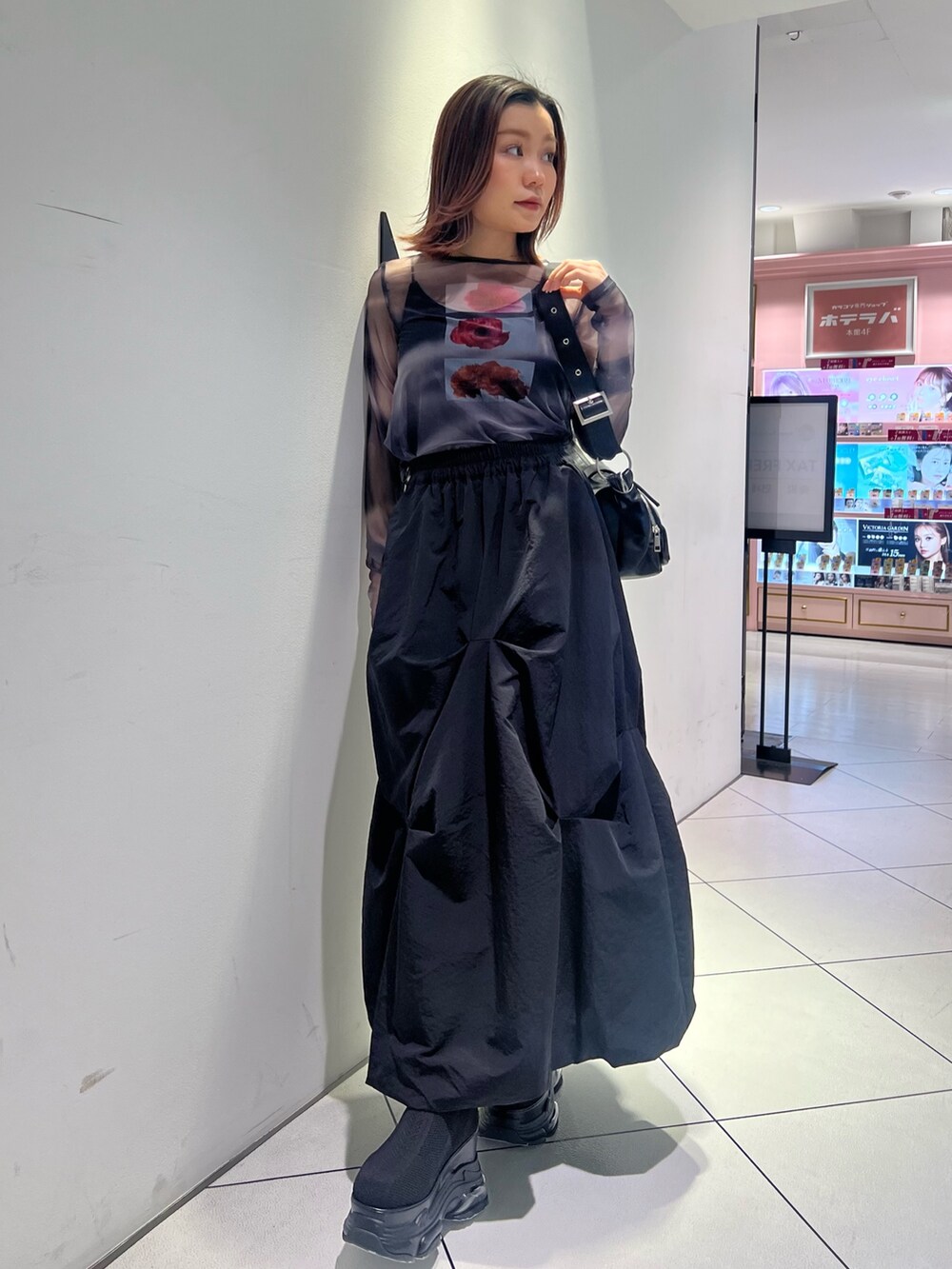 ブラック系のTシャツ/カットソー、ブラック系のスカート、ブラック系のブーツを着用したレディースの春コーディネートの3枚目の写真