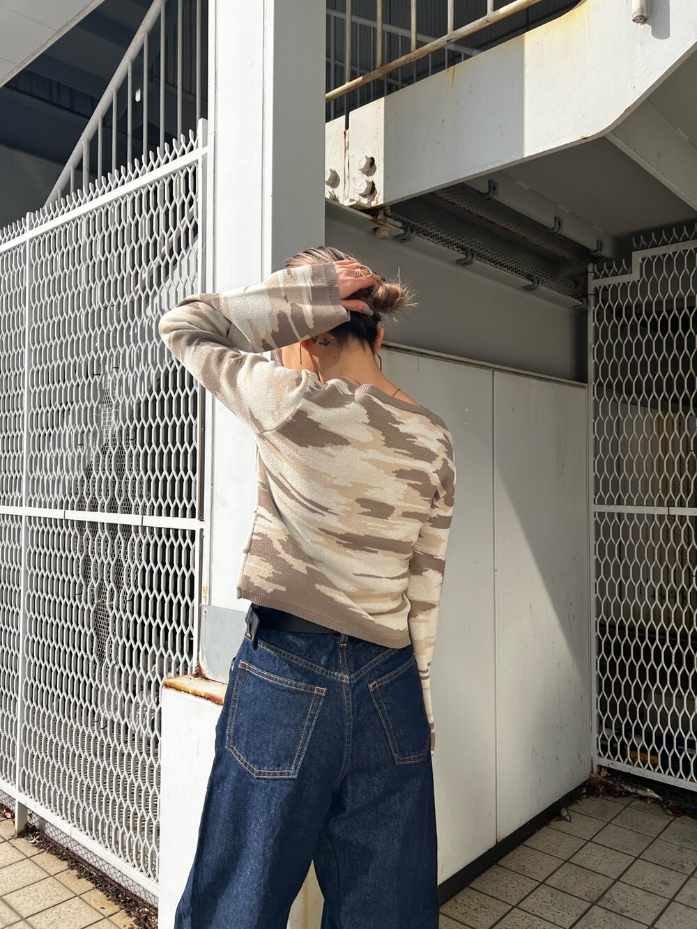 ブルー系のデニムパンツ、シルバー系のハンドバッグ、ベージュ系のカーディガン/ボレロを着用したレディースの冬コーディネートの6枚目の写真