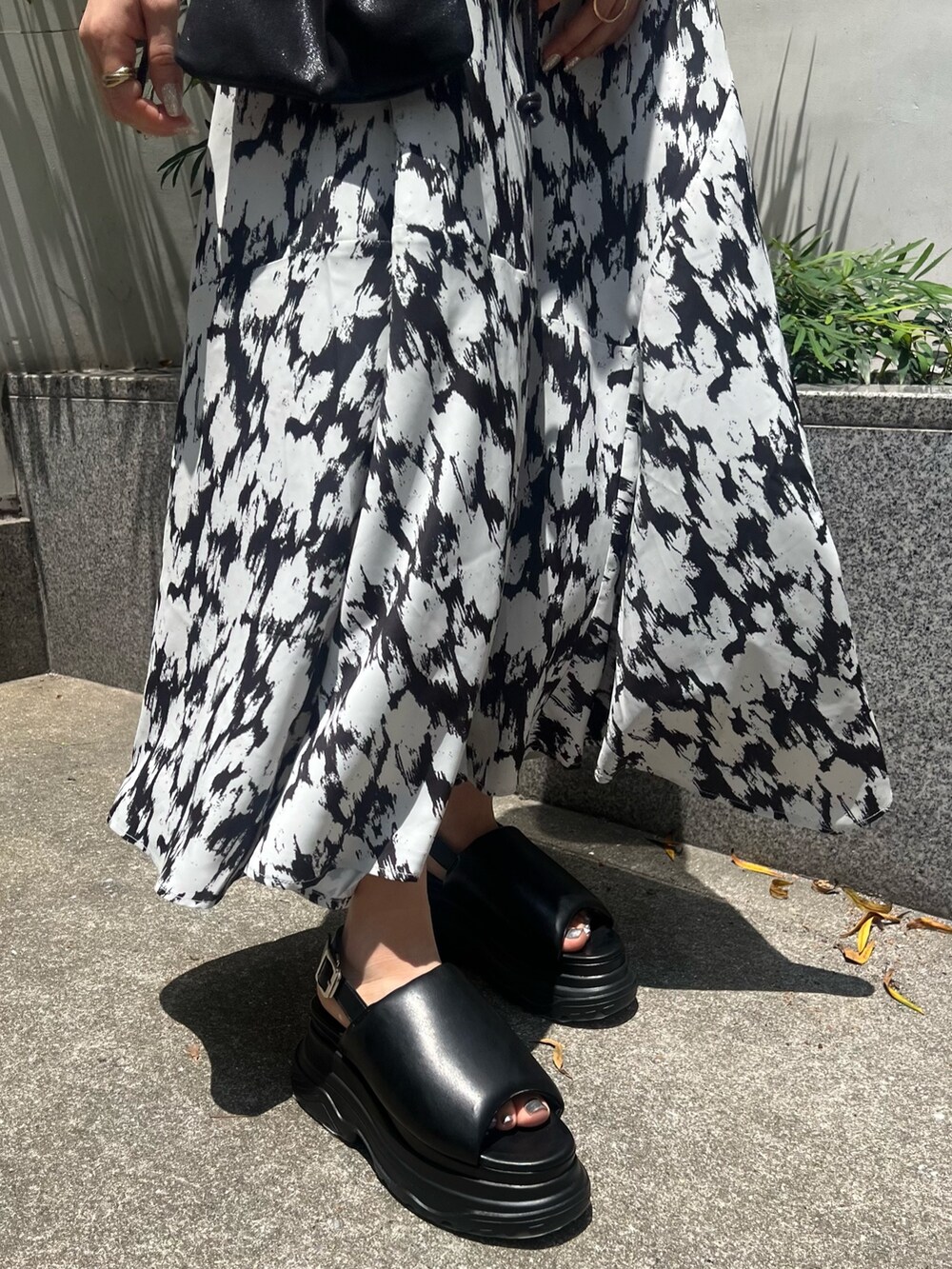 ホワイト系のワンピース、ブラック系のショルダーバッグ、ブラック系のサンダルを着用したレディースの夏コーディネートの8枚目の写真