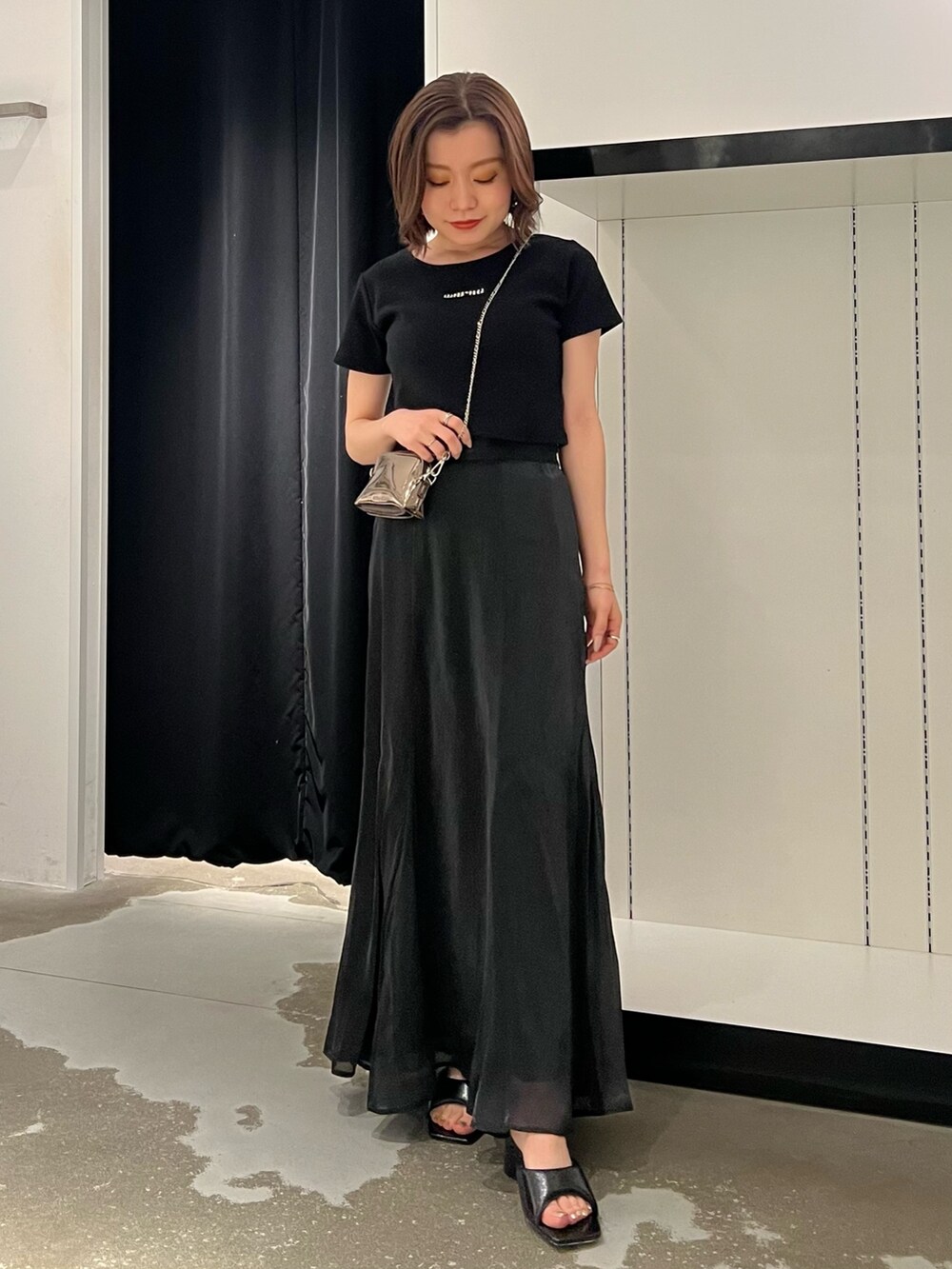 ブラック系のTシャツ/カットソー、ブラック系のスカート、ゴールド系のショルダーバッグを着用したレディースの夏コーディネートの3枚目の写真