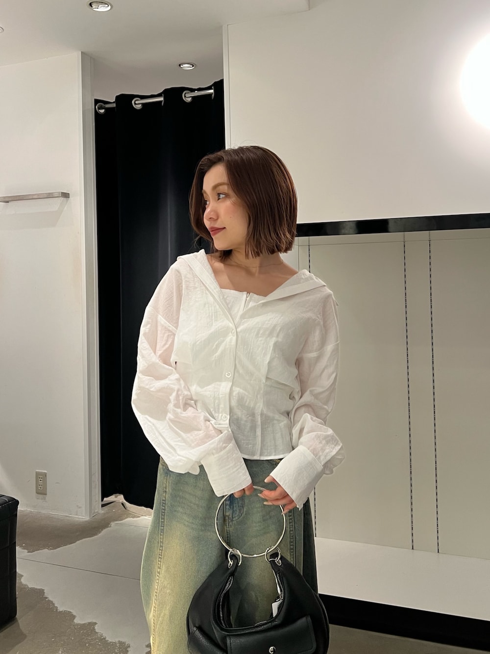 ホワイト系のシャツ/ブラウス、ブルー系のデニムパンツ、ブラック系のハンドバッグを着用したレディースの夏コーディネートの5枚目の写真