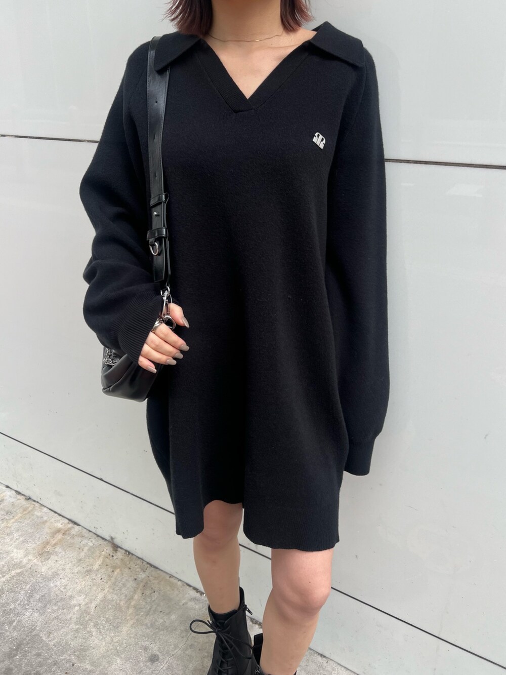 ブラック系のショルダーバッグ、ブラック系のブーツ、ブラック系のワンピースを着用したレディースの冬コーディネートの6枚目の写真