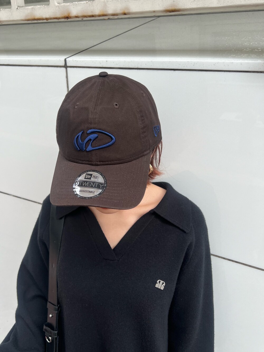 ブラック系のショルダーバッグ、ブラック系のブーツ、ブラック系のワンピースを着用したレディースの冬コーディネートの7枚目の写真