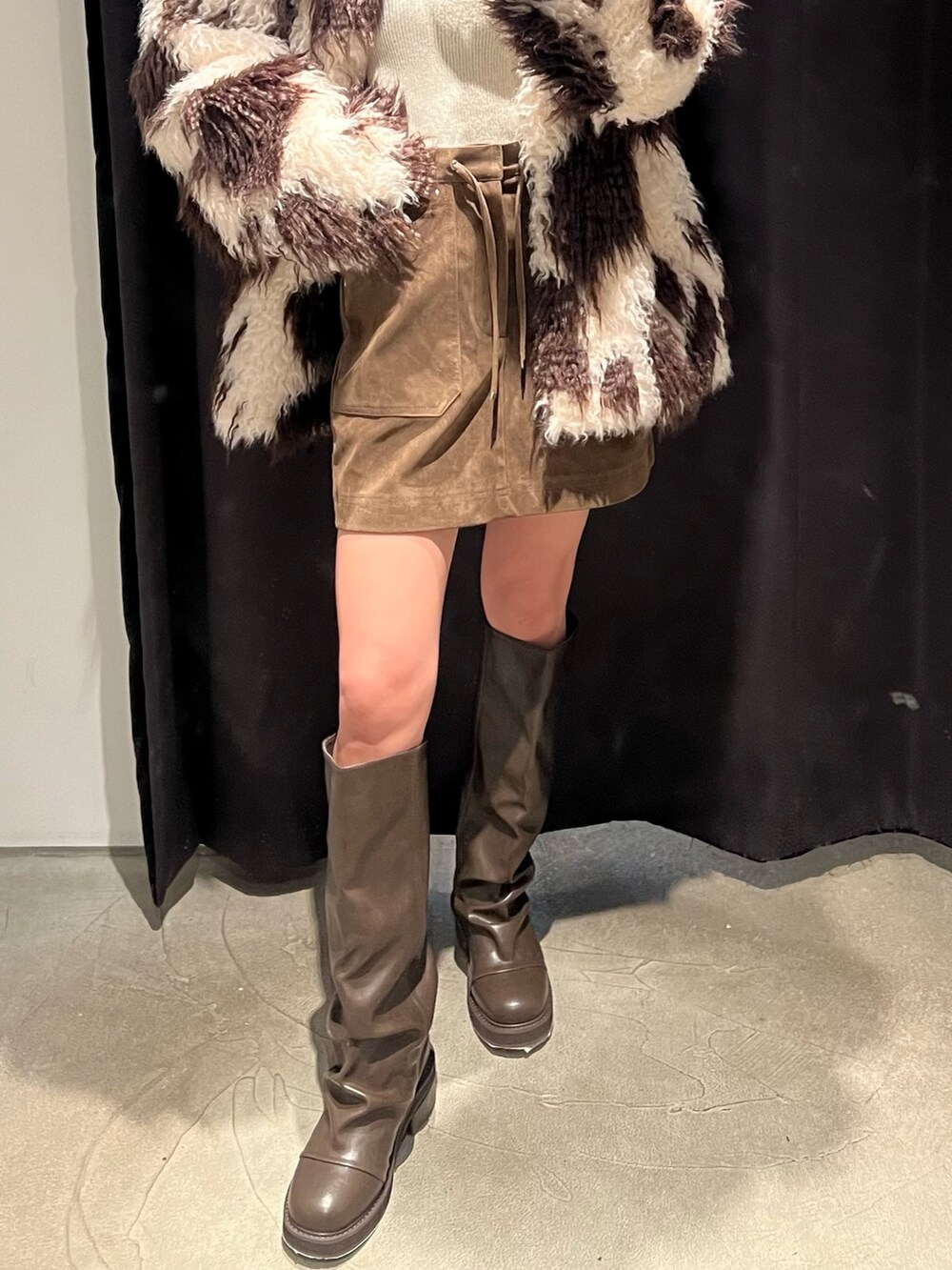 その他のブルゾン、ブラウン系のブーツ、ホワイト系のニット/セーターを着用したレディースの冬コーディネートの5枚目の写真