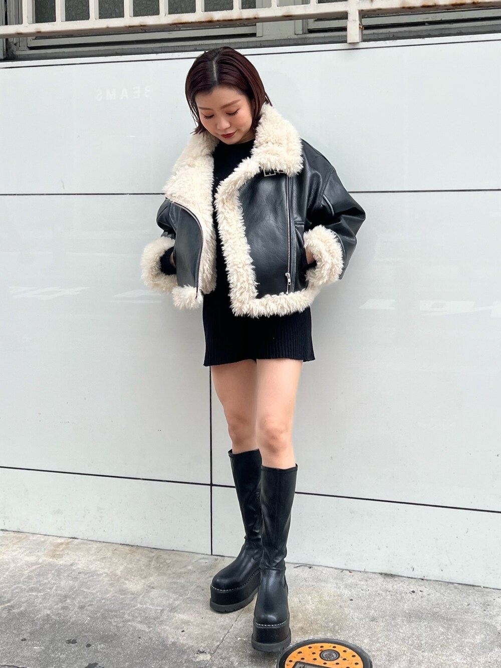 ブラック系のムートンコート、ブラック系のニット/セーター、ブラック系のその他パンツを着用したレディースの秋コーディネートの4枚目の写真