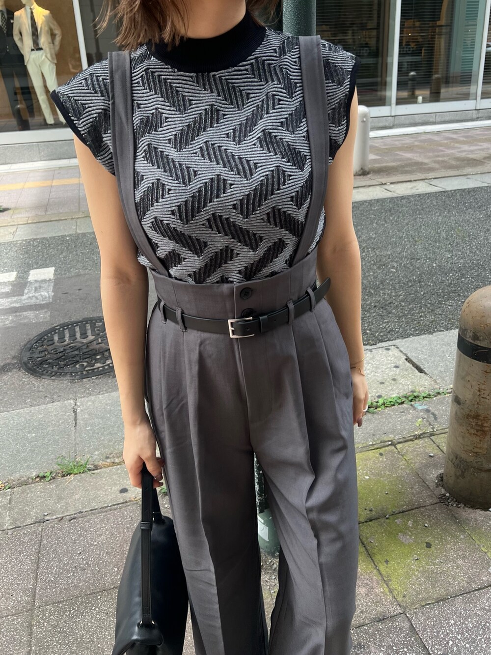 ブラック系のニット/セーター、グレー系のその他パンツ、ブラック系のハンドバッグを着用したレディースの夏コーディネートの7枚目の写真